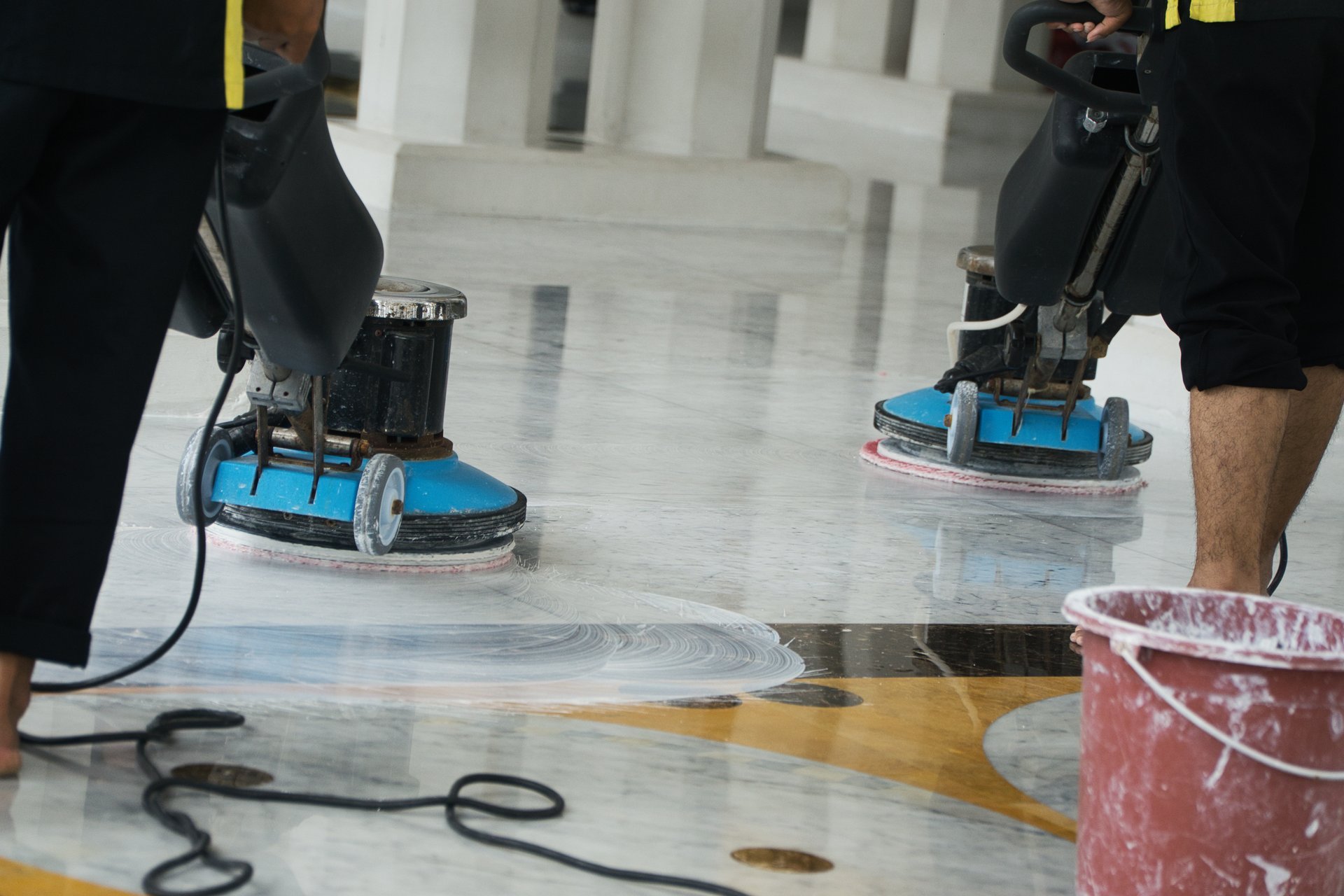Two technicians buffing and polishing a large marble floor in a North Carolina building