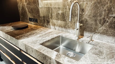 Elegant contemporary kitchen with luxurious dark stone countertop and modern faucet