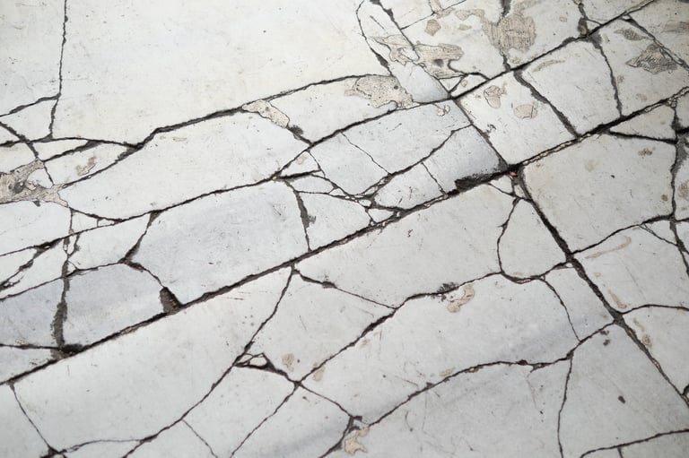 Marble floor with cracks and aged surface before restoration